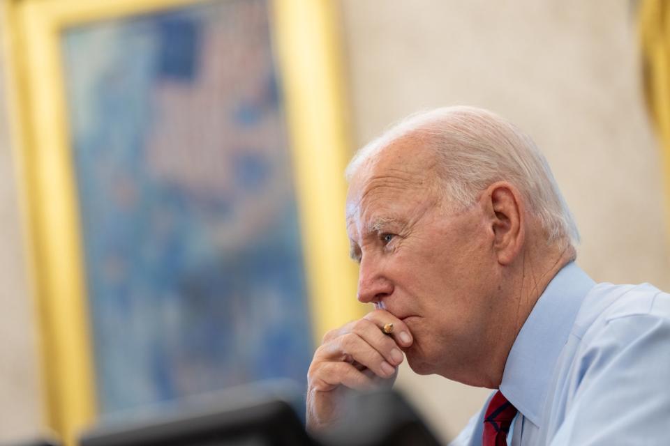 President Biden listening attentively to his senior advisors during a meeting.