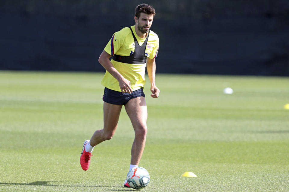 In this photo provided by FC Barcelona, Barcelona's Gerard Pique runs with the ball during a training session in Barcelona, Spain on Friday May 8, 2020. Soccer players in Spain returned to train for the first time since the country entered a lockdown nearly two months ago because of the coronavirus pandemic. (Miguel Ruiz/FC Barcelona via AP)