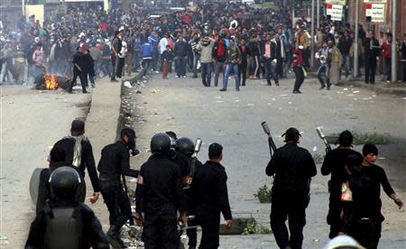 Supporters of the Muslim Brotherhood and ousted Egyptian President Mohamed Mursi run after riot police fired tear gas during clashes in Cairo December 20, 2013. REUTERS/Stringer