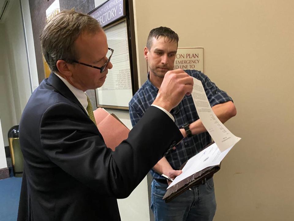 Chris Kise, attorney for Tiffany Carr, the former CEO of the Florida Coalition Against Domestic Violence, looks over a show-cause order passed by the House of Representatives being delivered to him Thursday in Tallahassee by Chris Compton of the Process Service of America.