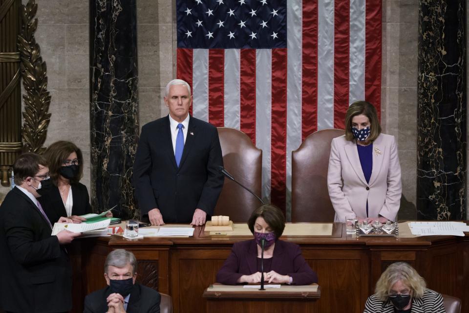 Vice President Mike Pence and Speaker of the House Nancy Pelosi, D-Calif., read the final certification of Electoral College votes cast in November's presidential election during a joint session of Congress after working through the night at the Capitol in Washington on Jan. 7. Violent protesters loyal to President Donald Trump stormed the Capitol, disrupting the process.