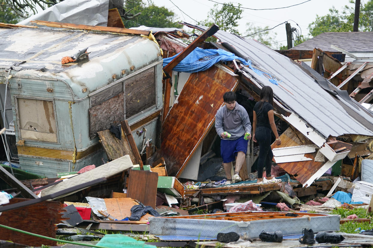 People salvage items from a home after a tornado hit Saturday, May 13, 2023, in the unincorporated community of Laguna Heights, Texas near South Padre Island. Authorities say one person was killed when a tornado struck the southernmost tip of Texas on the Gulf coast. (AP Photo/Julio Cortez)