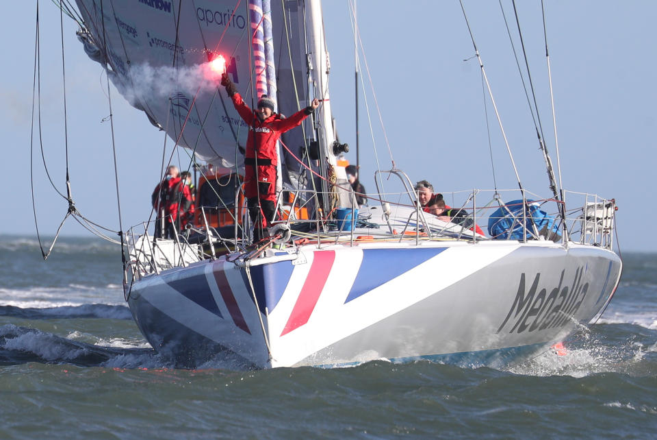 <p>Pip Hare holds a flare as she sails her boat Medallia into Poole, Dorset, after completing the Vendee Globe round-the-world yacht race. Picture date: Thursday February 18, 2021.</p>
