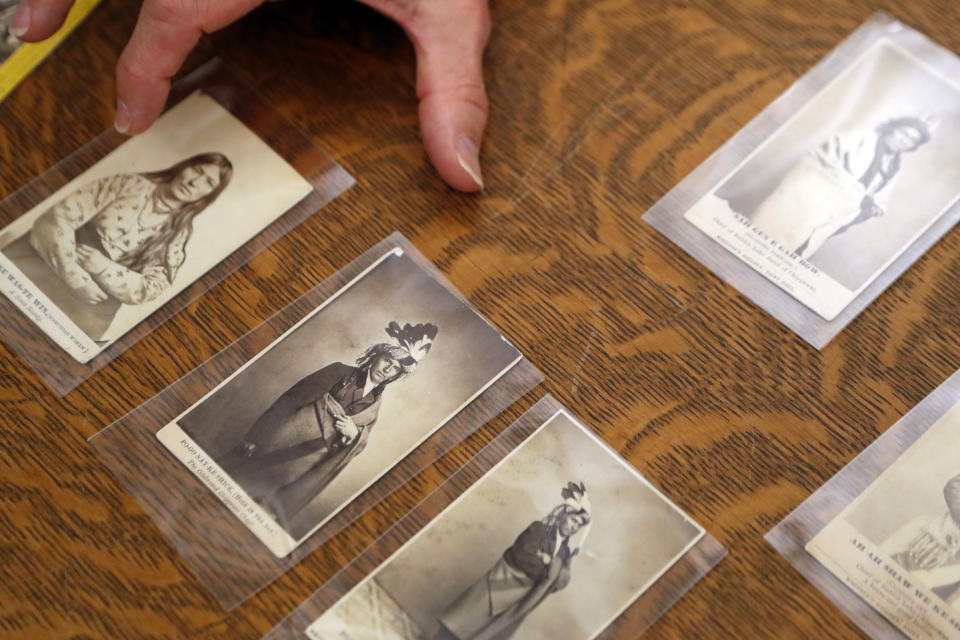 In this Thursday, Nov. 14, 2019 photo, University of Michigan William Clements Library Curator of Graphics, Clayton Lewis, shows examples of cartes de visite from the photographic collection acquired by the library in 2016 from Richard Pohrt Jr. in Ann Arbor, Mich. The trove, representing some 80 indigenous groups, includes photos from government-sponsored expeditions, stereographic and cartes de visites. (AP Photo/Carlos Osorio)