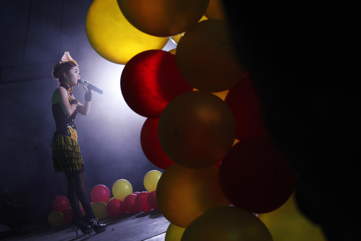 A performer sings at a "Getai", Mandarin for song stage, in Singapore August 15, 2013. The song stages, featuring animated singers in glittering costumes belting out Hokkien, Cantonese and Mandarin hits, are held in many neighbourhoods throughout Singapore during the "Hungry Ghost month" on the seventh lunar month, when spirits are believed to freely roam the earth, to entertain the living and the dead. Picture taken August 15, 2013. REUTERS/Edgar Su (SINGAPORE - Tags: RELIGION SOCIETY TRAVEL)