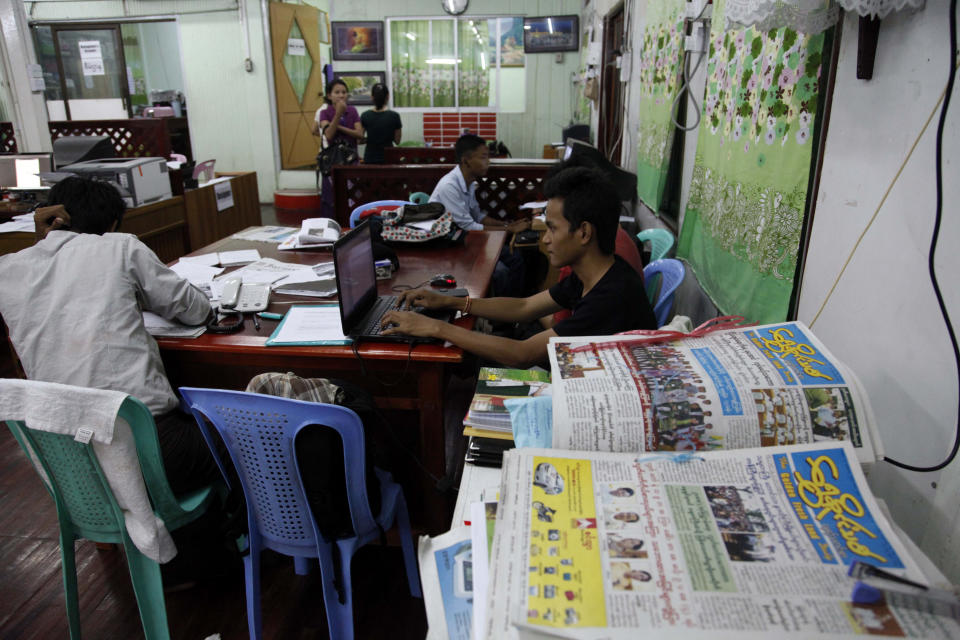 In this photo taken on March 11, 2014, staff members of “The Golden Fresh Land Daily” newspaper, work at their newsroom in Yangon, Myanmar. One year after publishers and editors took advantage of a decision by the country's nominally civilian government to lift a half-century-old ban on private dailies, the feeling of euphoria is fading. The struggle to compete with state-owned papers for advertisers and circulation have made it impossible for many to forge on. Golden Fresh Land, published its last edition Wednesday, March 12. It is the first well-known private daily to fold, but 11 others that are still publishing also appear to be struggling.(AP Photo/Khin Maung Win)