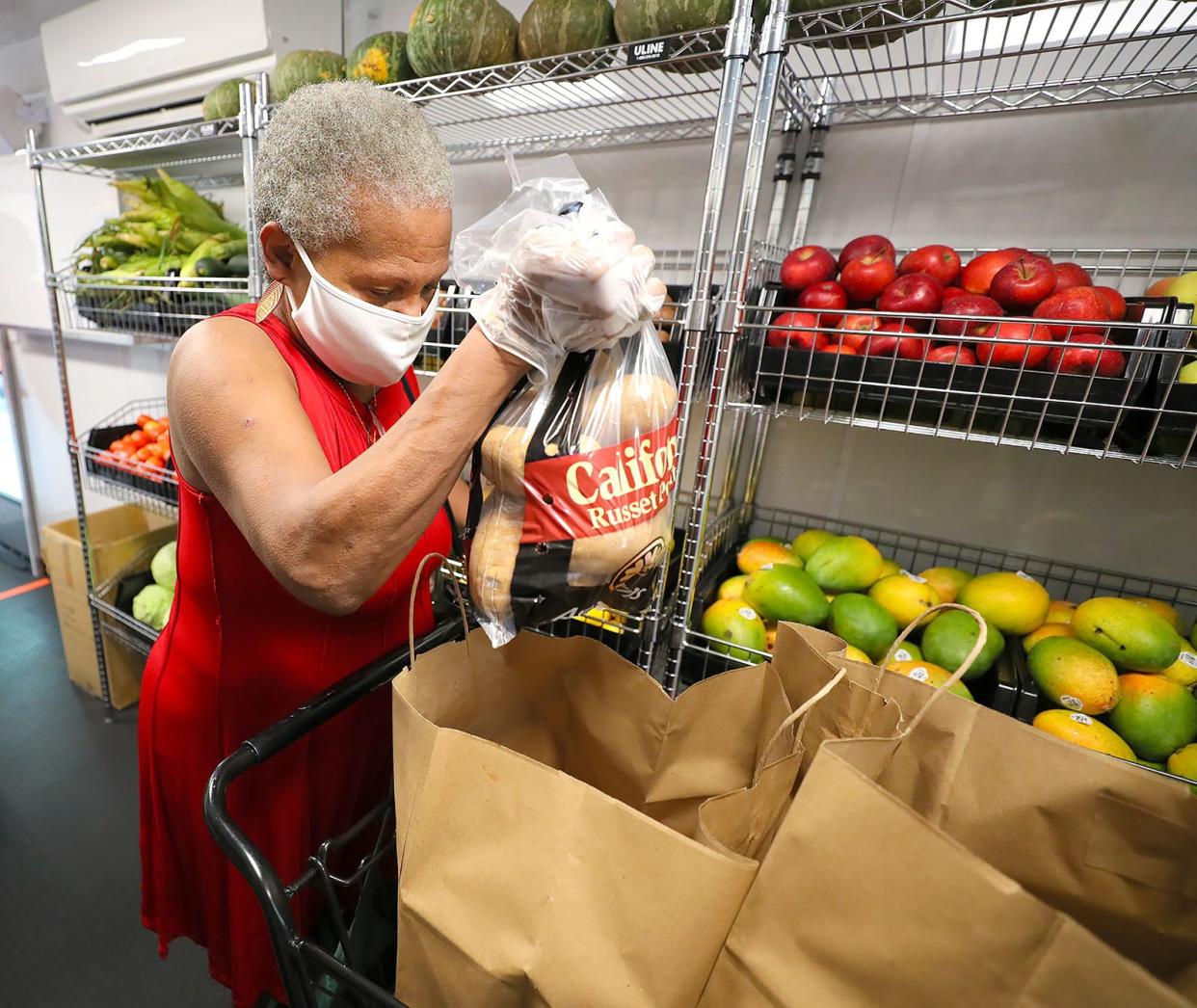 A woman gathers food at a mobile market of the Jacksonville-based Feeding Northeast Florida food bank.