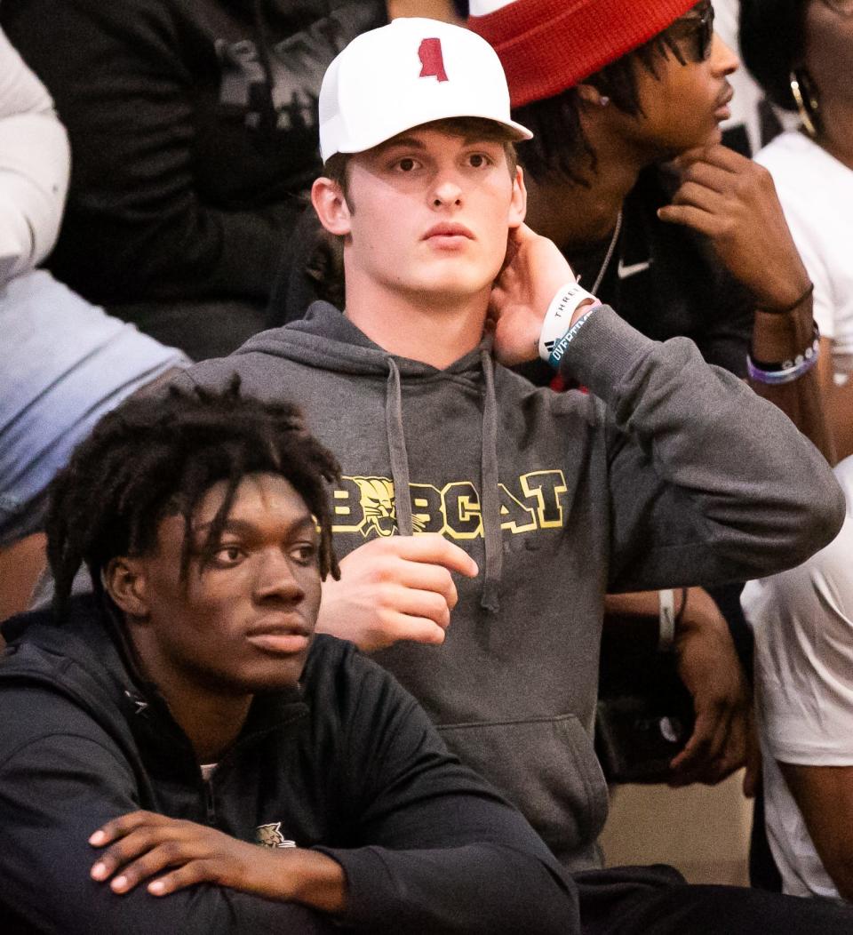 Buchholz Quarterback Creed Whittemore wears a Mississippi State hat, left, while sitting next to fellow teammate wide receiver Jaren Hamilton, right, wearing an Alabama beanie while watching the Gainesville Hurricanes hosting the P.K. Yonge Blue Wave at Gainesville High School in Gainesville, FL on Tuesday, November 29, 2022. Whittemore recently committed to Mississippi State while Hamilton recently committed to Alabama. The Hurricanes won 57-54. [Doug Engle/Ocala Star Banner]
