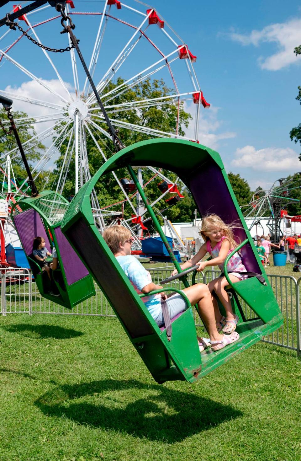 Savanna, 5, laughs with her grandmother Sandy as they spin on a ride at the Centre County Grange Encampment and Fair on Friday, Aug. 18, 2023.  