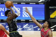 Minnesota Timberwolves forward Anthony Edwards, left, shoots against Chicago Bulls center Wendell Carter Jr., during the second half of an NBA basketball game in Chicago, Wednesday, Feb. 24, 2021. (AP Photo/Nam Y. Huh)