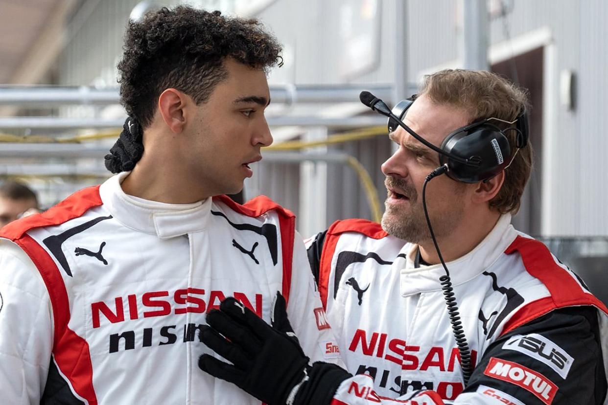 The two men look at each other in their white Nissan racing suits. Madekwe is tall with dark curly hair while Harbour is shorter and almost blonde, with a goatee.