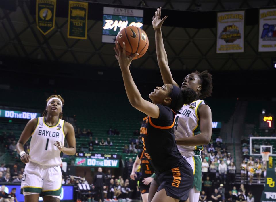 Oklahoma State guard Micah Dennis attempts a shot past Baylor center Queen Egbo, right, during the first half of an NCAA college basketball game Wednesday, Jan. 19, 2022, in Waco, Texas.