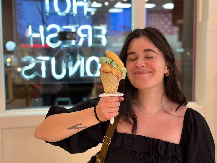 Anna (me!) holds an ice cream cone piled high with pistachio, sherbet, and chocolate ice cream. I smile with no teeth showing, and my eyes are closed.