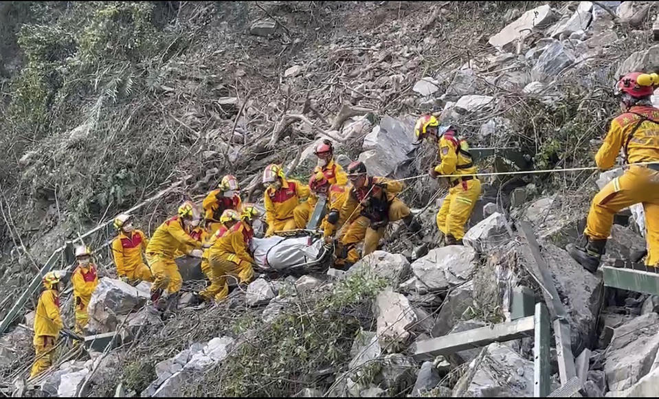 In this photo taken Thursday, April 4, 2024 and released by Pingtung Fire Department, firefighters evacuate a body from the Taroko National Park a day after a powerful earthquake struck, in the Hualien county, eastern Taiwan. Rescuers are searching for people out of contact a day after Taiwan's strongest earthquake in a quarter century damaged buildings, caused multiple rockslides. (Pingtung Fire Department via AP)