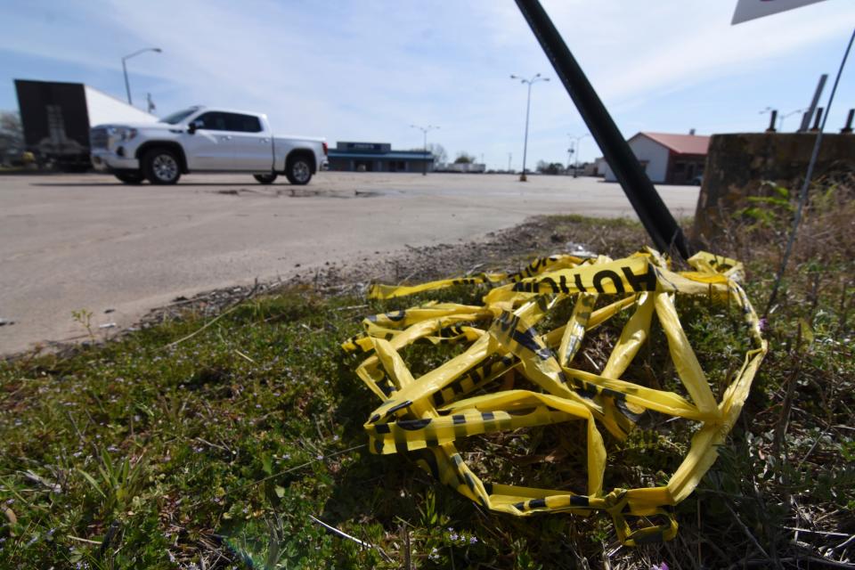 Crime scene tape lies on the ground Sunday after a shooting at a car show in Dumas, Arkansas.