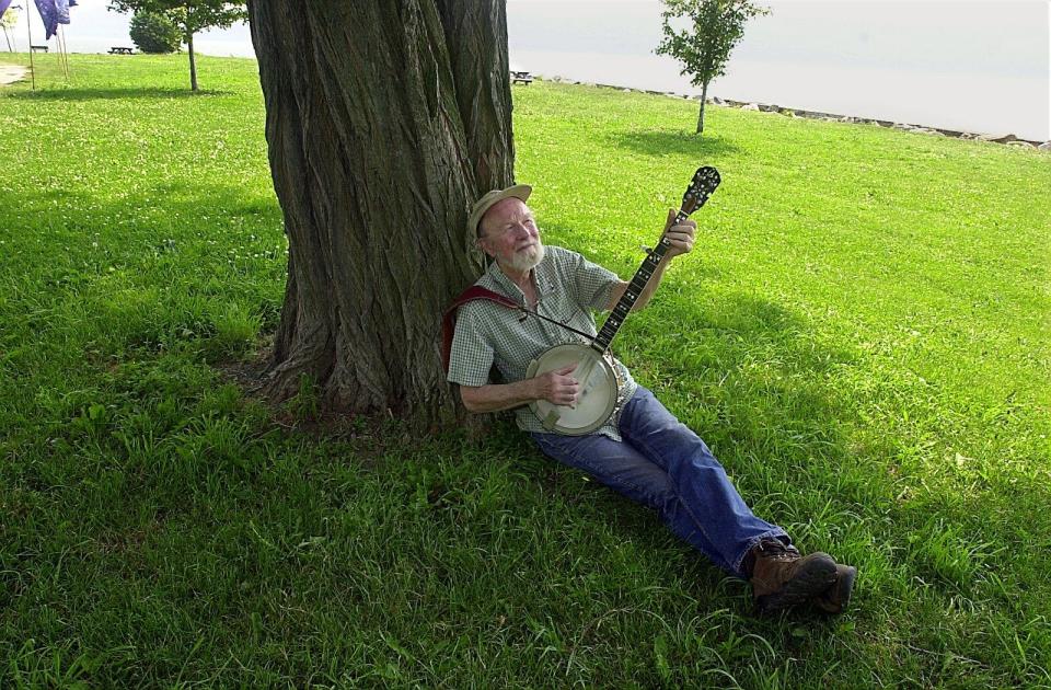 Folk singer Pete Seeger plays a borrowed banjo as he sits under a tree at Croton Point Park Friday in 2001.