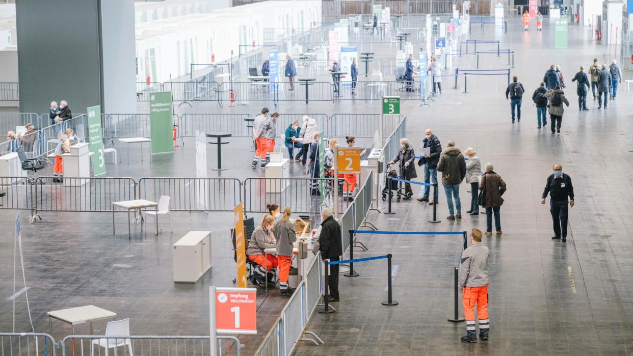 People arrive for vaccination against the COVID-19 disease at a vaccination center at the fairgrounds in Hannover, Germany, Monday, Feb. 1, 2021. Because of the vaccine shortage, only four of eight vaccination lines are in operation at the center.