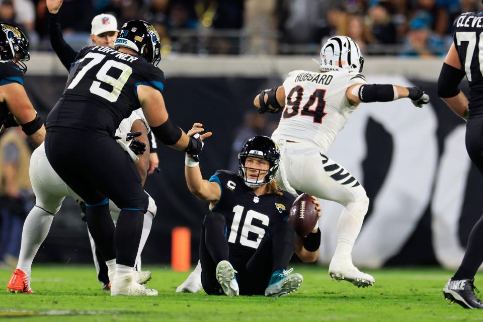 Jacksonville Jaguars quarterback Trevor Lawrence (16) is helped up by center Luke Fortner (79) after being sacked by Cincinnati Bengals defensive end Sam Hubbard (94) during the second quarter of a regular season NFL football matchup Monday, Dec. 4, 2023 at EverBank Stadium in Jacksonville, Fla. The Cincinnati Bengals defeated the Jacksonville Jaguars 34-31 in overtime. [Corey Perrine/Florida Times-Union]