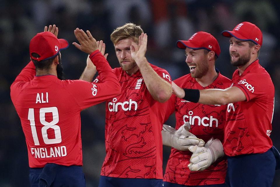 England's David Willey, center, celebrates with teammates after taking the wicket of Pakistan's Iftikhar Ahmed during the seventh twenty20 cricket match between Pakistan and England, in Lahore, Pakistan, Sunday, Oct. 2, 2022. (AP Photo/K.M. Chaudary)