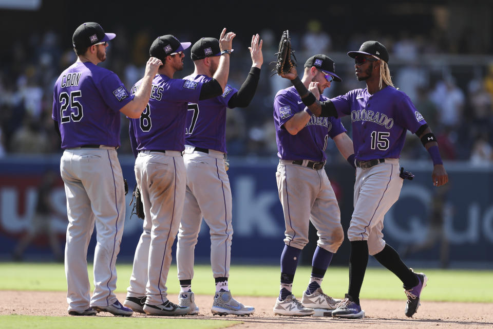 Colorado Rockies, Raimel Tapia, right, celebrates with Garrett Hampson, second from right, Trevor Story, center, Joshua Fuentes, second from left, and C.J. Cron, left, after defeating the San Diego Padres in a baseball game Sunday, July 11, 2021, in San Diego. (AP Photo/Derrick Tuskan)