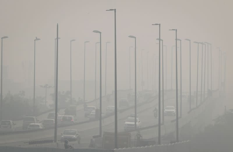 FILE PHOTO: Traffic moves on a flyover on a smoggy morning in New Delhi