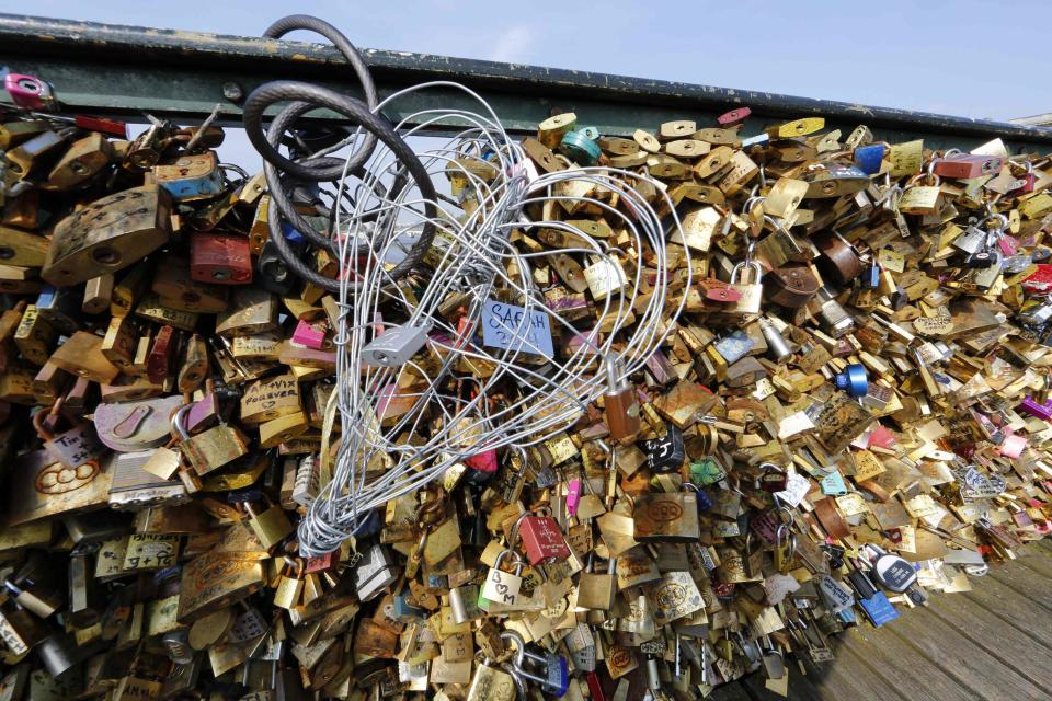 Padlocks clipped by lovers are seen on the fence of the Pont des Arts over the River Seine in Paris September 23, 2014. (REUTERS/Jacky Naegelen)