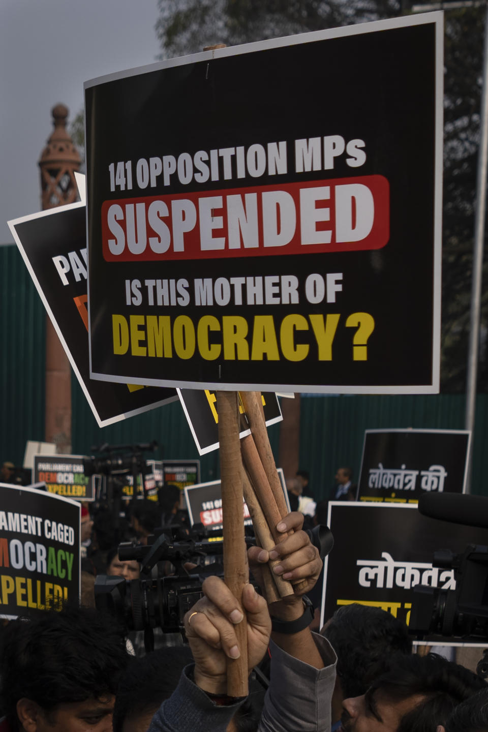 Suspended lawmakers hold placards as they march briefly outside the Parliament House in New Delhi, India, Thursday, Dec. 21, 2023. Dozens of opposition lawmakers suspended from Parliament by Prime Minister Narendra Modi's government for obstructing proceedings in the chamber held a street protest on Thursday accusing the government of throttling democracy in the country. (AP Photo/Altaf Qadri)