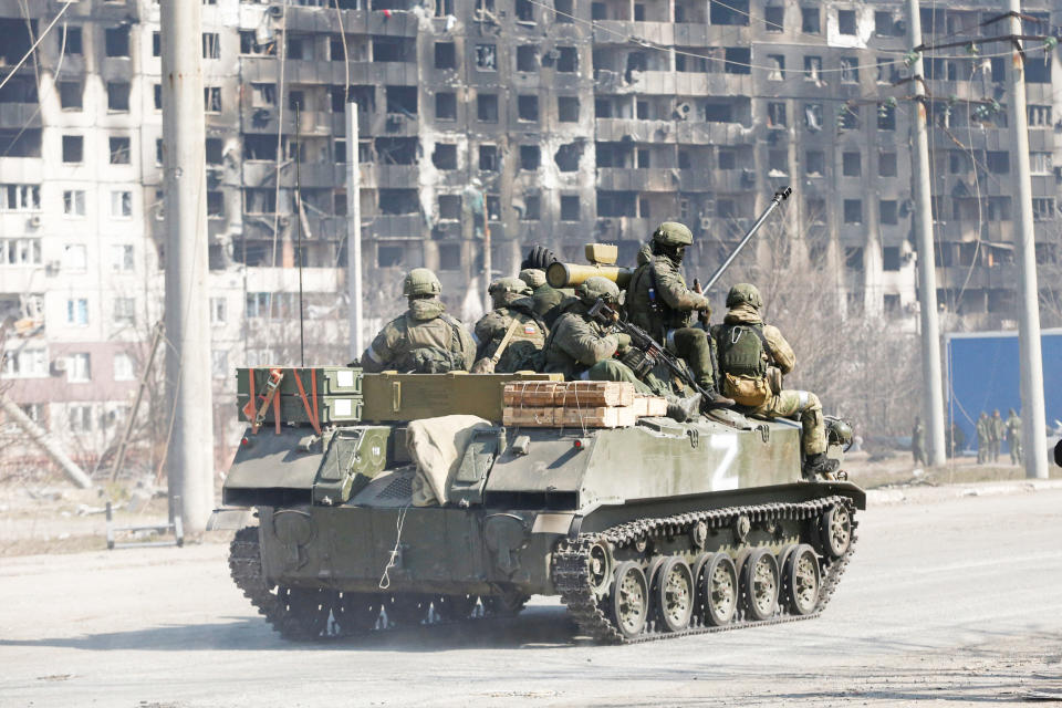 Service members of pro-Russian troops are seen atop of an armoured vehicle (Alexander Ermochenko / Reuters)