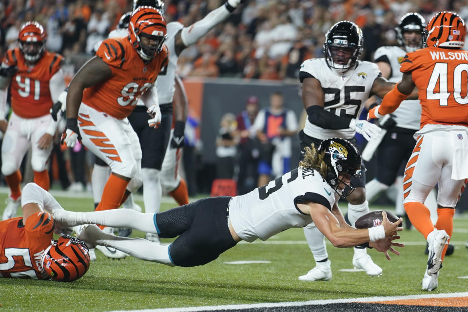 Jacksonville Jaguars quarterback Trevor Lawrence (16) dives in for touchdown while being tackled by Cincinnati Bengals' Logan Wilson (55) during the first half of an NFL football game, Thursday, Sept. 30, 2021, in Cincinnati. (AP Photo/Michael Conroy)