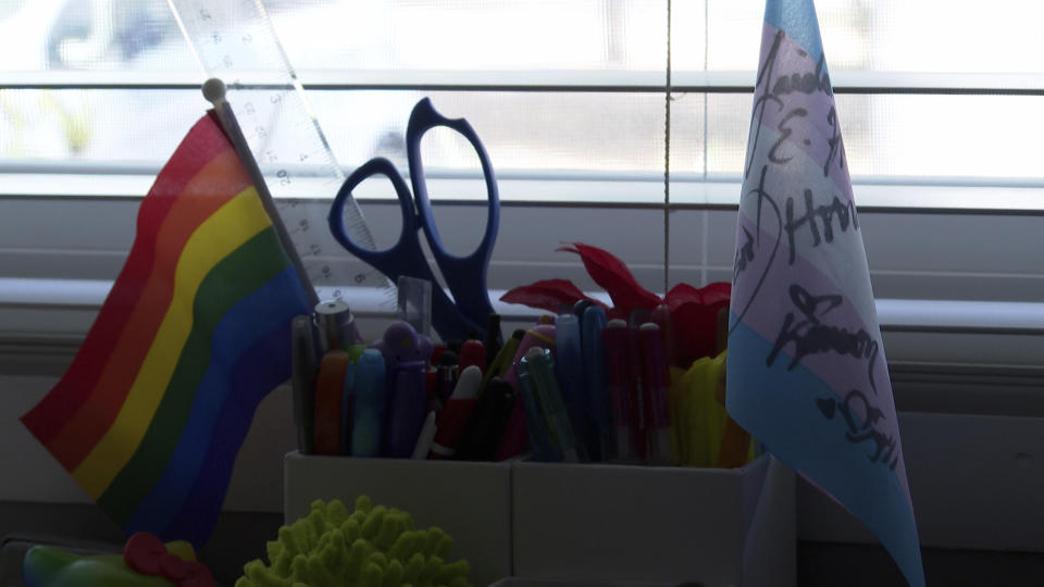 Flags that represent transgender and LGBTQ+ rights on Charlie Suor’s desk at his home in Tampa, Fla. on March 26, 2023. Carys Mullins, a Florida teenager has documented how it feels to be young and transgender for a film set to debut at a festival as transgender people around the world celebrate visibility and lawmakers across the country look to restrict their rights and care. (AP Photo/Laura Bargfeld)