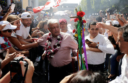 FILE PHOTO: Leftist front-runner Andres Manuel Lopez Obrador of the National Regeneration Movement (MORENA) greets supporters during a campaign rally in Uruapan, in Michoacan state, Mexico, June 8, 2018. REUTERS/Alan Ortega/File Photo