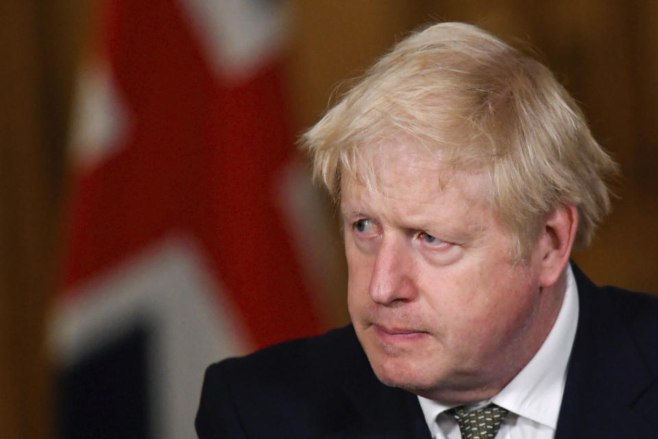 Britain's Prime Minister Boris Johnson listens during a coronavirus briefing in Downing Street, London, Monday, Oct. 12, 2020. (Toby Melville/Pool Photo via AP)