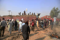 Supporters of Tehreek-e-Labiak Pakistan, a radical Islamist party, stand on shipping containers placed by police to block them during their protest march toward Islamabad, on a highway in the town of Sadhuke, in eastern Pakistan, Wednesday, Oct. 27, 2021. Violence at the anti-France Islamist rally in Sadhuke left at least one police officer and two demonstrators dead. ​They demanded the expulsion of France's envoy to Pakistan over publication of caricatures of Islam's Prophet Muhammad in France. (AP Photo/K.M. Chaudary)