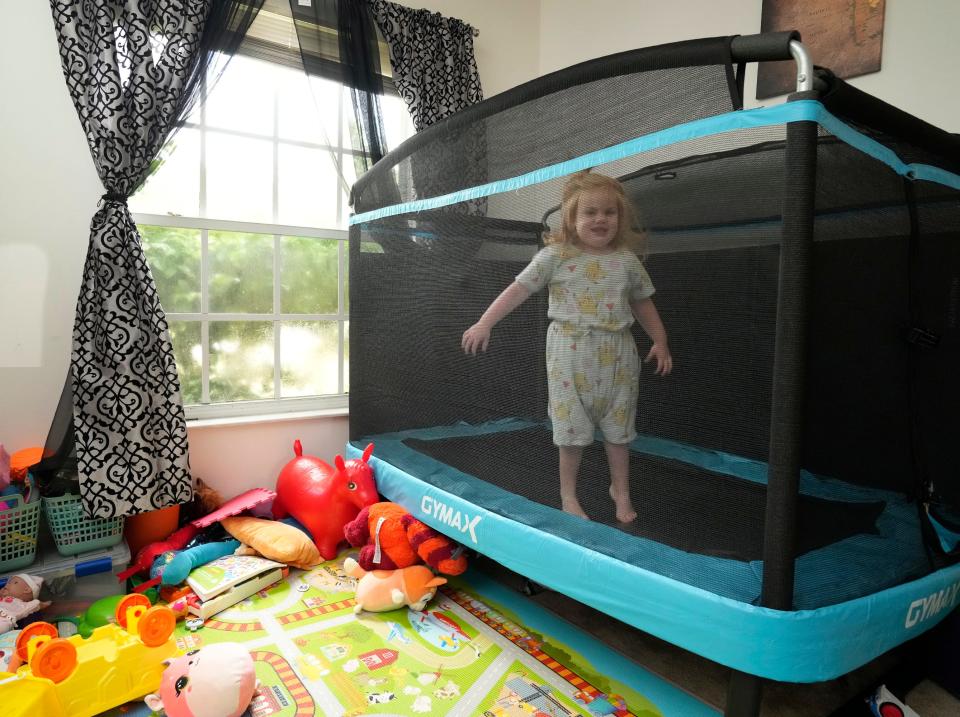 Veda Ulrich bounces on a mini-trampoline in the family's Palm Coast home. The family is trying to raise funds to be considered for a gene therapy trial that might cure the effects of Sanfilippo Syndrome on their daughter.