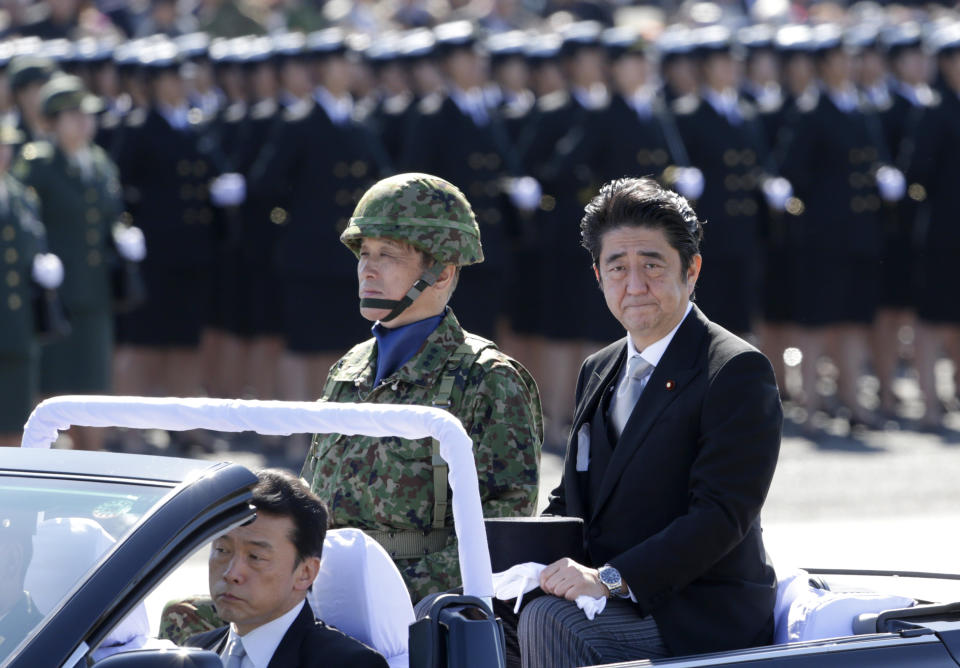 FILE - Japanese Prime Minister Shinzo Abe, right, reviews members of Japan Self-Defense Forces (SDF) during the Self-Defense Forces Day at Asaka Base, north of Tokyo on Oct. 27, 2013. Former Japanese Prime Minister Abe, a divisive arch-conservative and one of his nation's most powerful and influential figures, has died after being shot during a campaign speech Friday, July 8, 2022, in western Japan, hospital officials said. (AP Photo/Shizuo Kambayashi, File)
