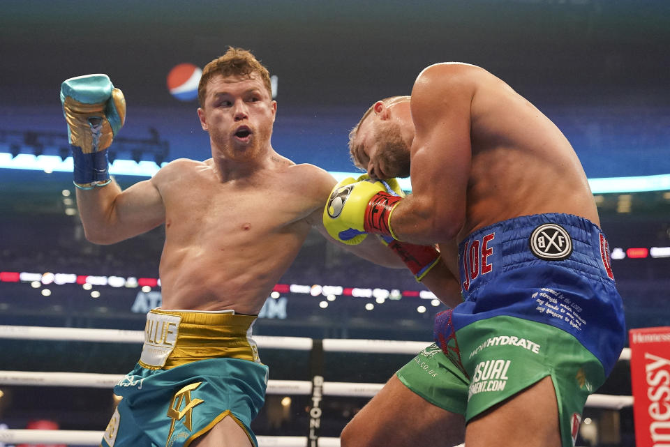 Canelo Alvarez, left, exchanges punches with Billy Joe Saunders during a unified super middleweight world championship boxing match, Saturday, May 8, 2021, in Arlington, Texas. (AP Photo/Jeffrey McWhorter)