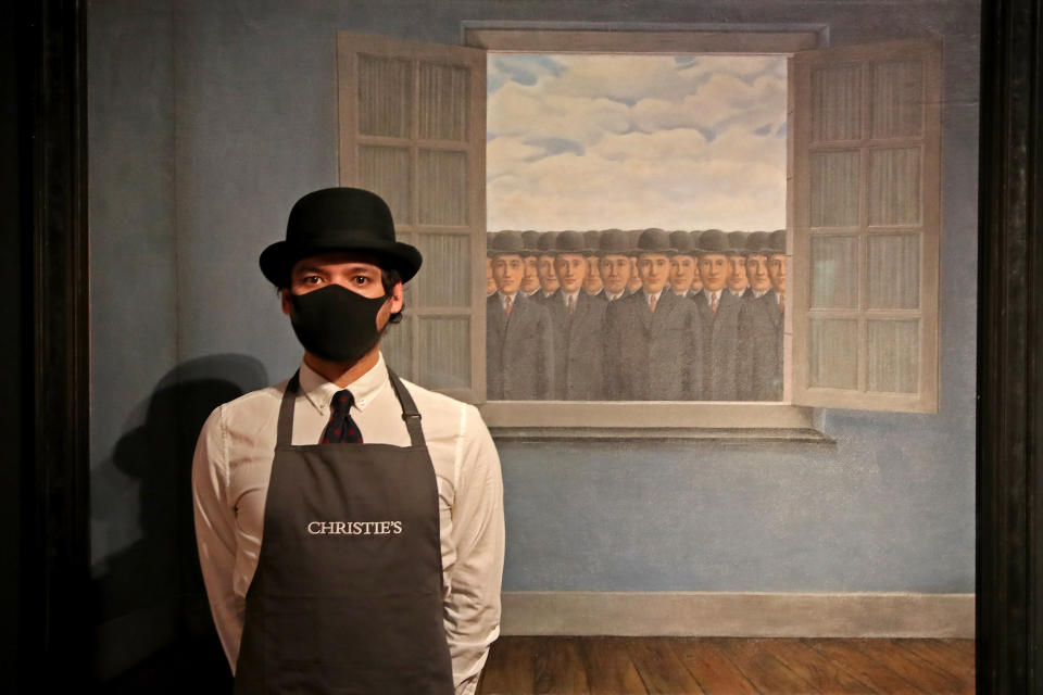 <p>LONDON, ENGLAND - MARCH 16: An art worker stands next to Rene Margritte's 'Le mois des vendanges' during preparations for the livestreamed art sales at Christie’s Auction House on March 16, 2021 in London, England. The livestreamed sales include the "20th Century Art Evening" and "The Art of The Surreal". (Photo by Chris Jackson/Getty Images)</p>
