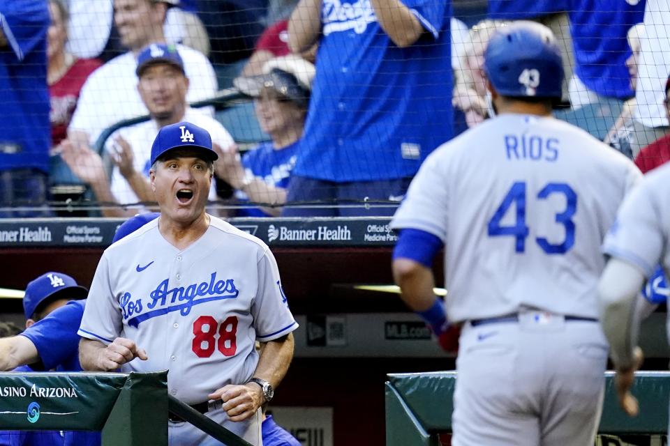 Los Angeles Dodgers bench coach Bob Geren (88) reacts as Dodgers' Edwin Rios (43) returns to the dugout after hitting a three-run home run against the Arizona Diamondbacks during the second inning of a baseball game Friday, May 27, 2022, in Phoenix. (AP Photo/Ross D. Franklin)