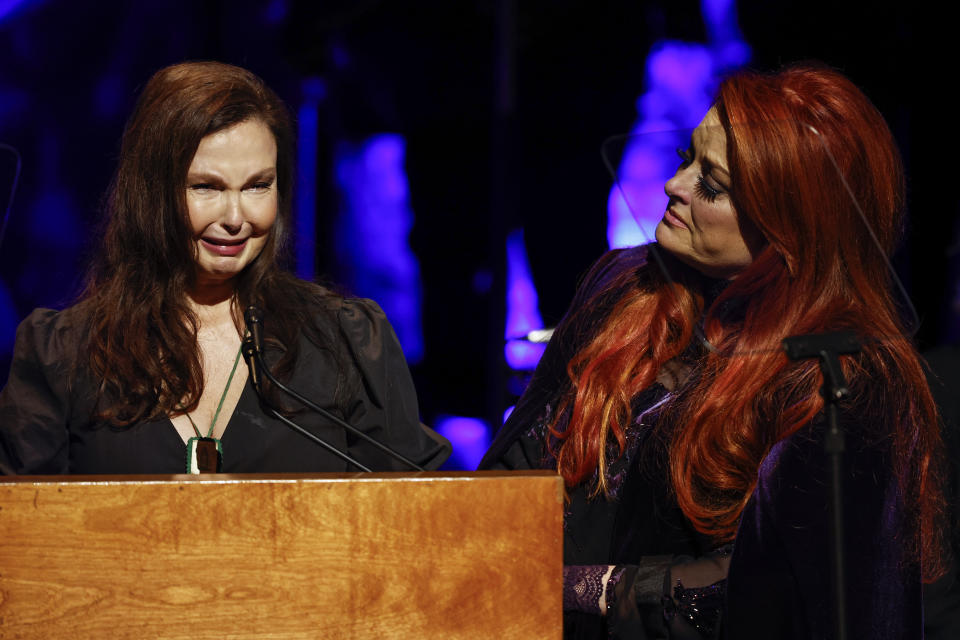 Ashley Judd, left, cries as she speaks as sister Wynonna Judd watches during the Medallion Ceremony at the Country Music Hall of Fame Sunday, May 1, 2022, in Nashville, Tenn. (Photo by Wade Payne/Invision/AP)
