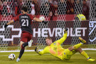 Toronto FC midfielder Jonathan Osorio (21) gets the ball past Sporting Kansas City goalkeeper Tim Melia, but there was an offside call, negating the apparent goal, during the first half of an MLS soccer match Saturday, March 30, 2024, in Toronto. T(Frank Gunn/The Canadian Press via AP)