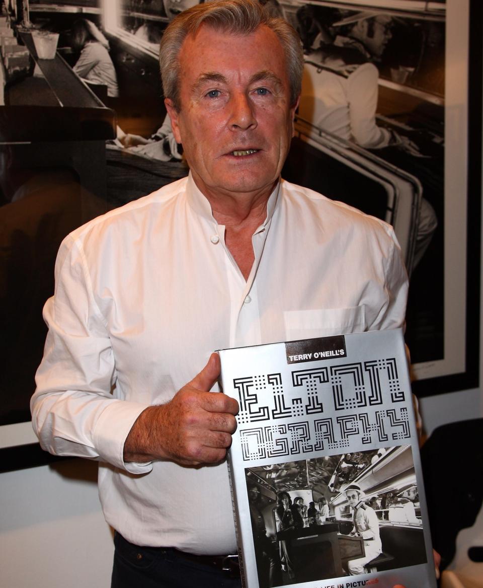 Late photographer Terry O'Neill posing with his book "Eltonography A Life in Pictures" at his exhibition of the same name in 2008.