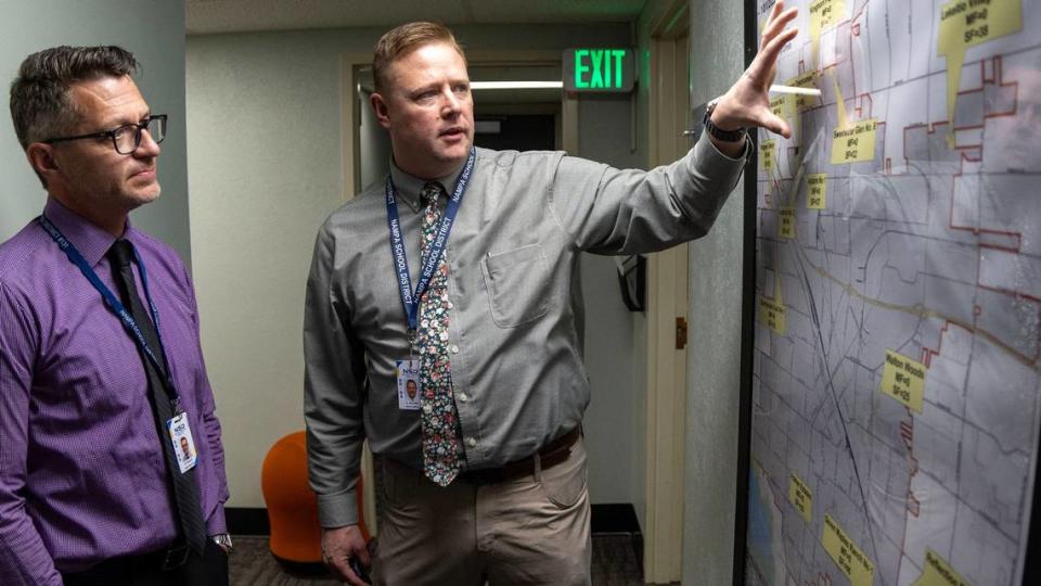 Director of Operations Cortney Stauffer, right, and Nampa School District Superintendent Dr. Gregg Russell, left, look at a map of Nampa showing areas of growth in their school district—and areas of declining enrollment.