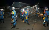 Police officers check a collapsed house after an earthquake in Mashiki town, Kumamoto prefecture, southern Japan, in this photo taken by Kyodo April 16, 2016. REUTERS/Kyodo