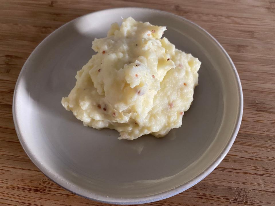 Pile of mashed potatoes on a plate.