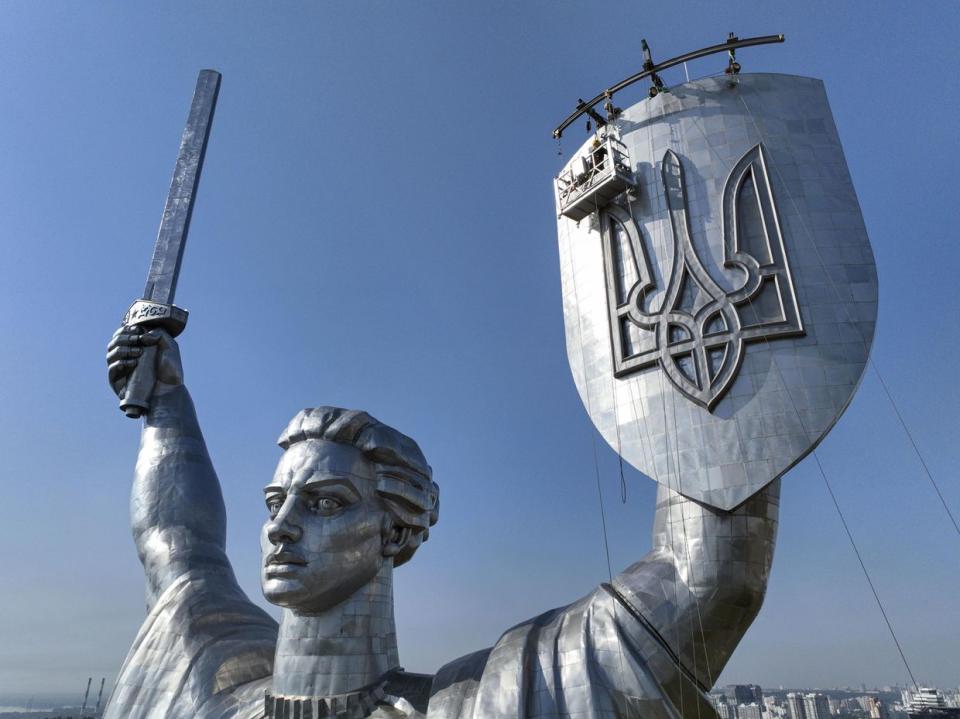 Photo taken from a drone on Aug. 20, 2023, shows the Motherland monument in Kyiv, with the Ukrainian trident insignia being installed on a shield in the statue's left hand. The Soviet hammer and sickle symbol was removed in July, amid the Russian invasion of the country. (Photo by Kyodo News via Getty Images)