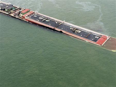 A barge loaded with marine fuel oil sits partially submerged in the Houston Ship Channel in this U.S. Coast Guard picture taken March 22, 2014. REUTERS/US Coast Guard/Handout via Reuters