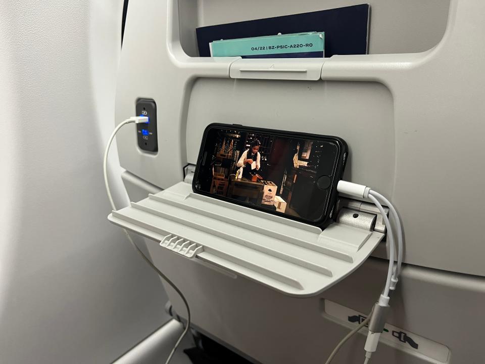 A phone rests on a small tray on the back of a seat on a Breeze Airways flight on March 18, 2023.