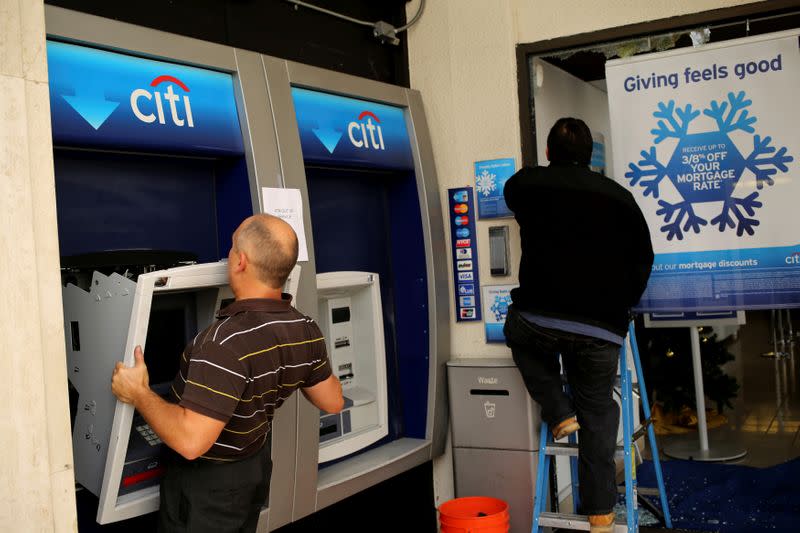 FILE PHOTO: A worker replaces an ATM machine at a bank building on Shattuck Avenue, in Berkeley