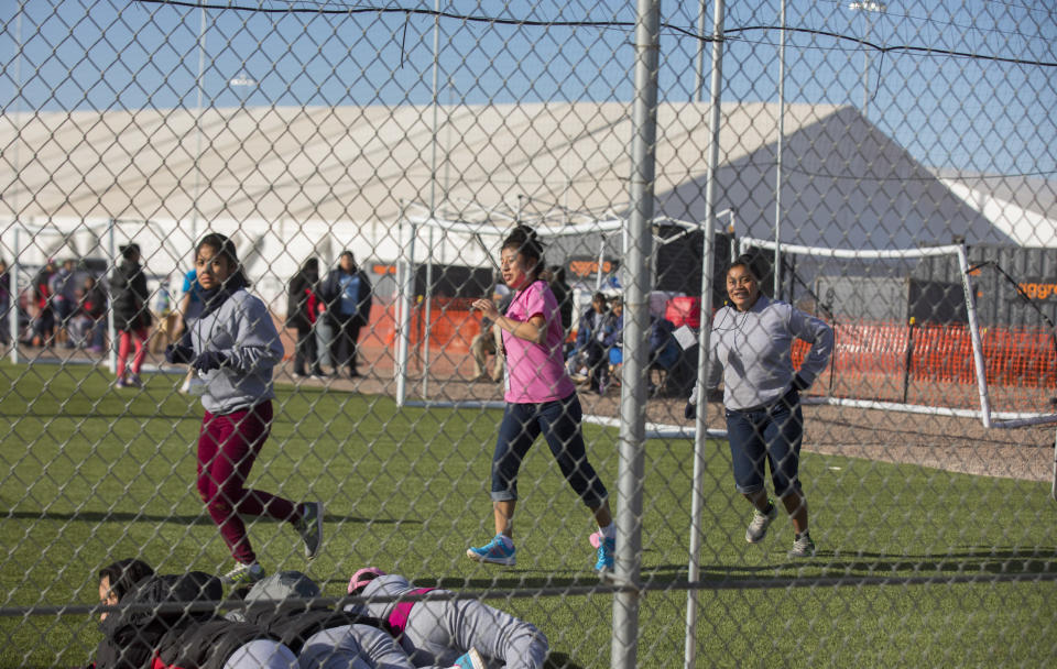 CORRECTS TO CLARIFY TEENS WERE JUST RUNNING AND NOT LOOKING AT PROTESTERS, AS THERE WERE NO PROTESTS THAT DAY - In this Nov. 25, 2018 photo provided by Ivan Pierre Aguirre, migrant teens held inside the Tornillo detention camp run at the facility in Tornillo, Texas. The Trump administration announced in June 2018 that it would open the temporary shelter for up to 360 migrant children in this isolated corner of the Texas desert. Less than six months later, the facility has expanded into a detention camp holding thousands of teenagers - and it shows every sign of becoming more permanent. (Ivan Pierre Aguirre via AP)