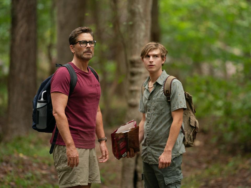 Rob Lowe, Johnny Berchtold standing in the woods in a scene from dog gone